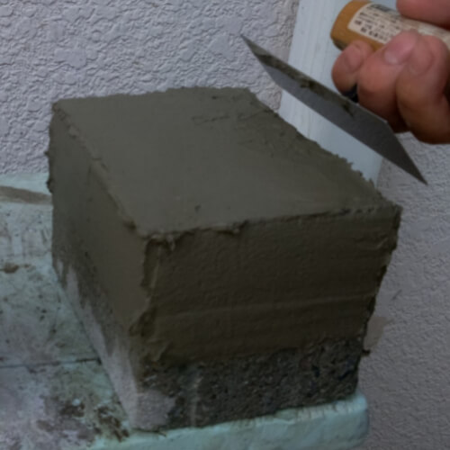 ヒマラヤ岩塩岩塩と天然鉱石専門店 人がナイフを使ってコンクリートブロックを作っています。