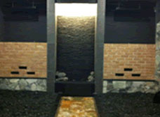 黒いタイル張りの床と石の壁が特徴的なバスルーム。